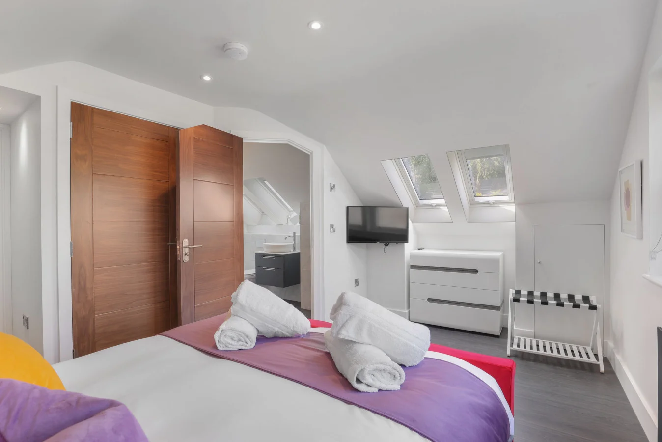 King bedroom with wall-mounted TV and walk-in wardrobe