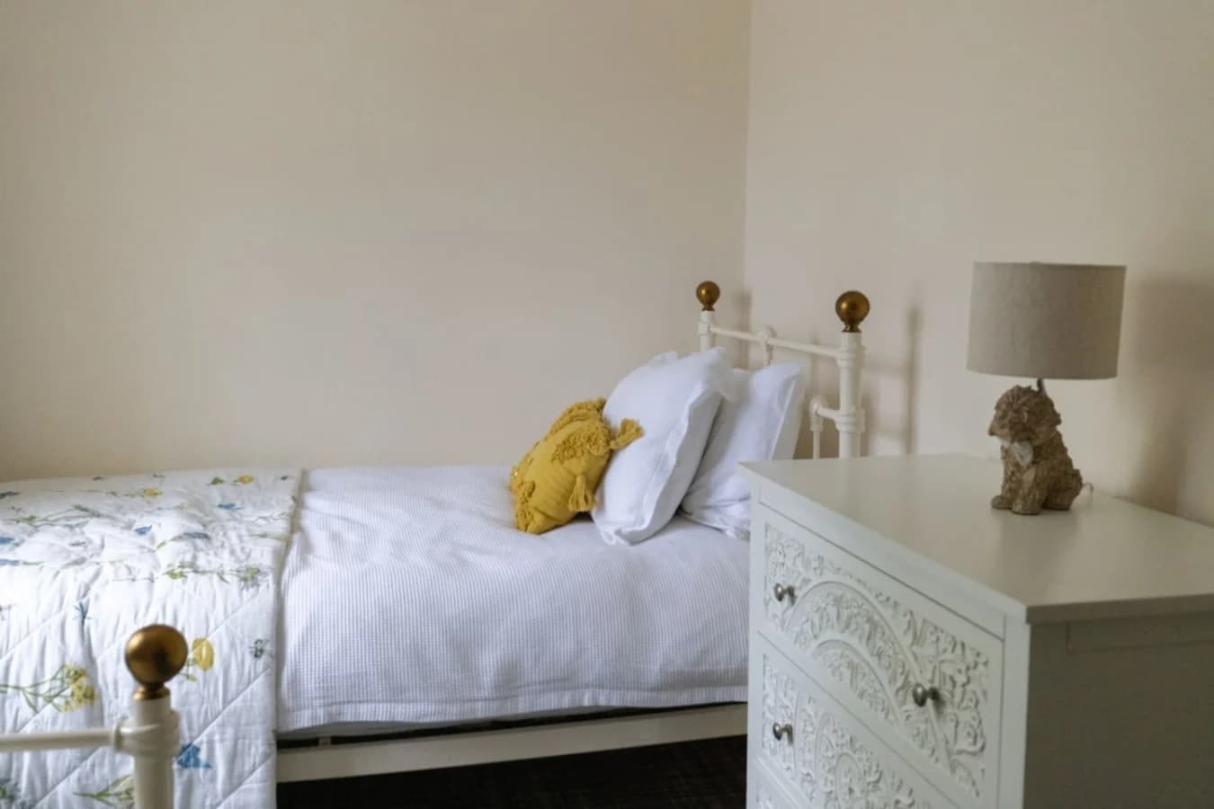 Bright twin room with brass bed frames and calming neutral tones