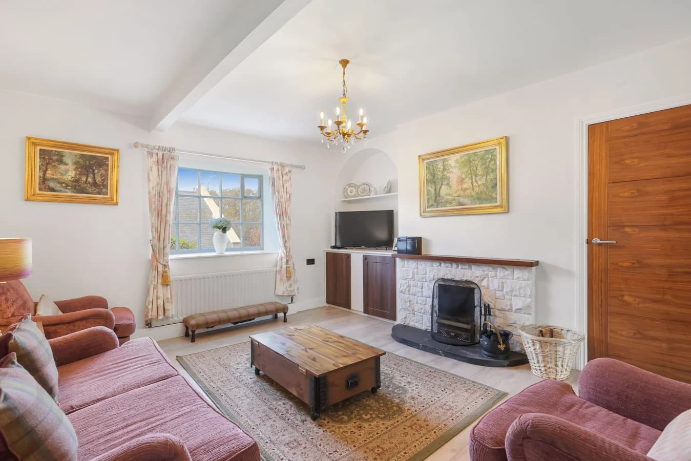 Sitting room with open fire, TV cabinet and traditional furnishings