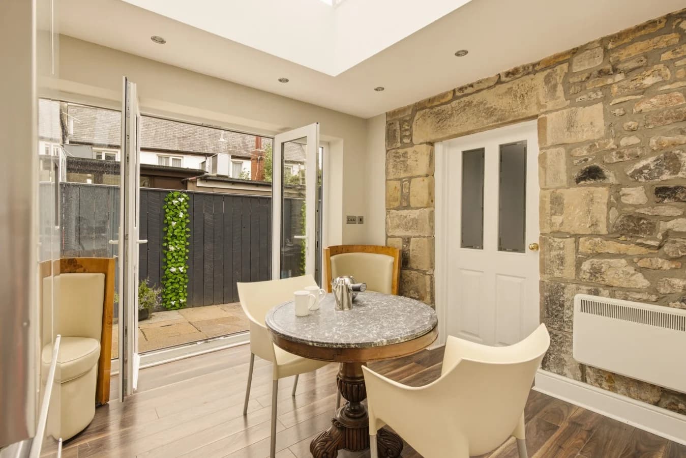 Orangery seating area with exposed stone walls and skylight