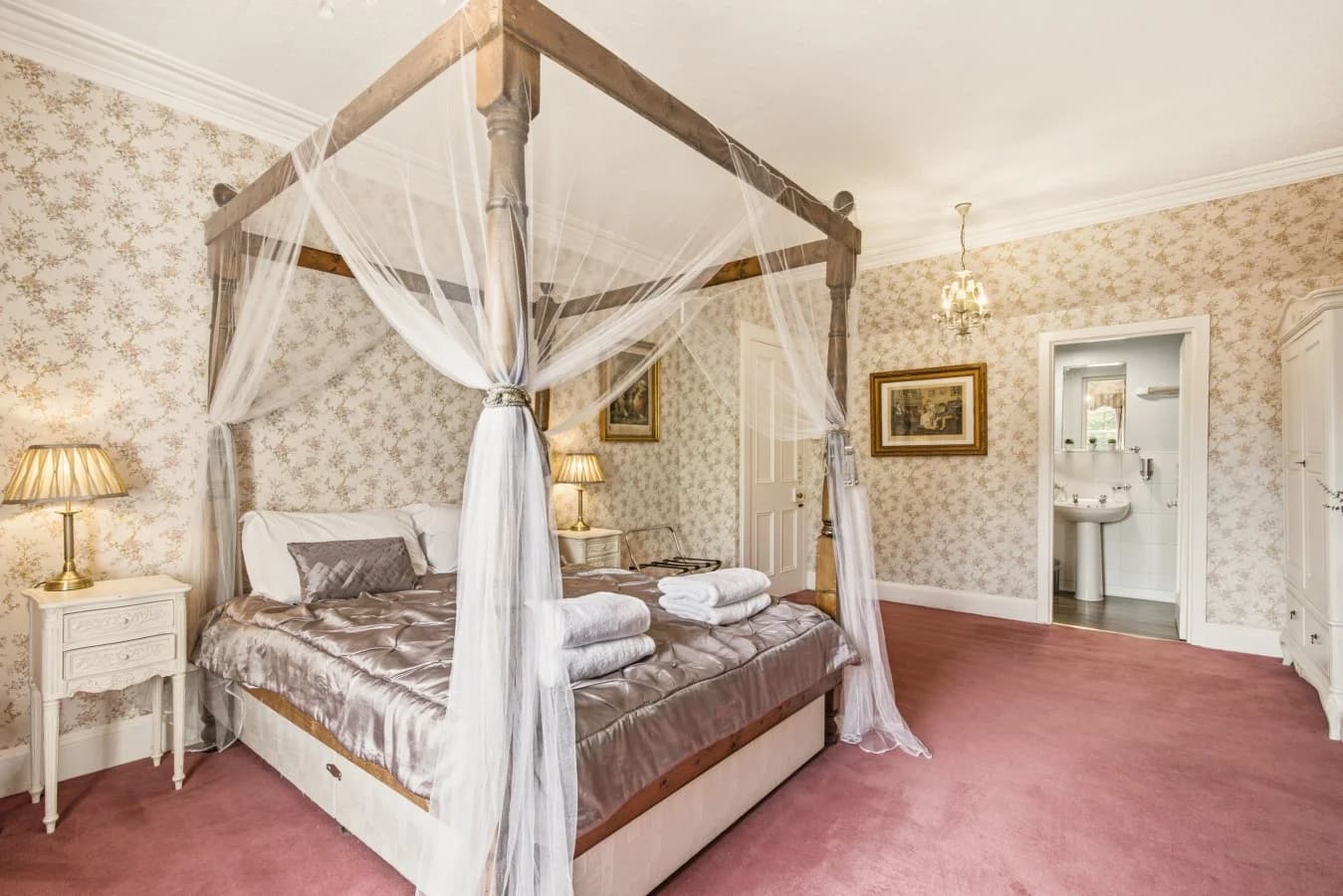 Principal bedroom with four-poster bed, floral décor and garden views