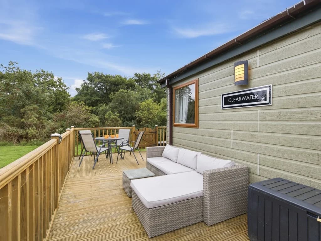 Private deck with outdoor seating and dining furniture beside the lodge