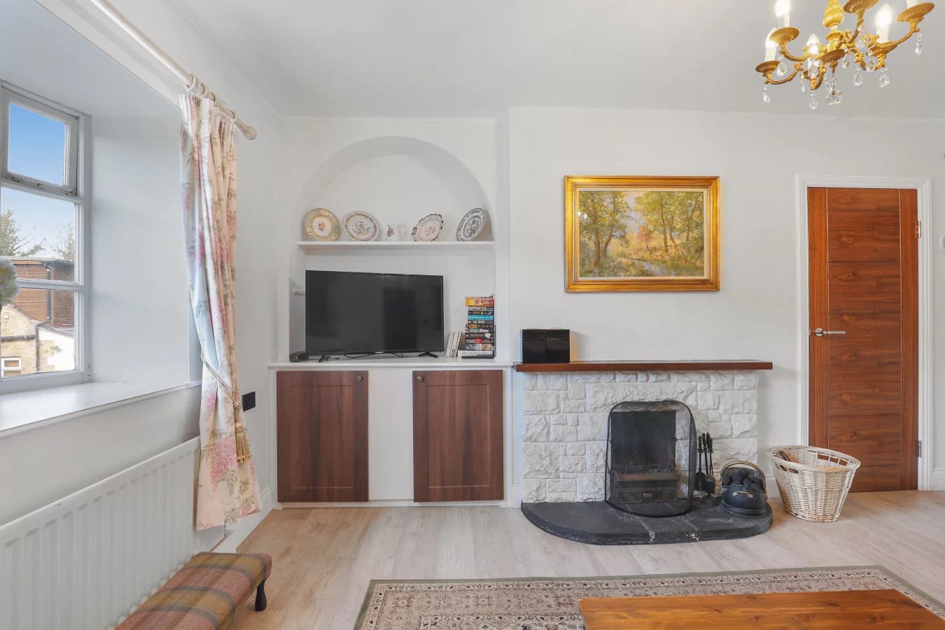 Open fireplace with stone surround and television cabinet