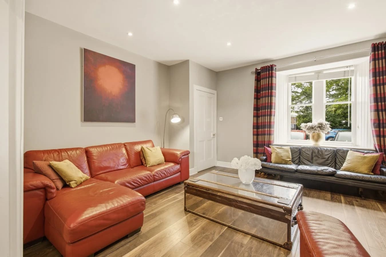 Living room with red leather sofa and feature artwork