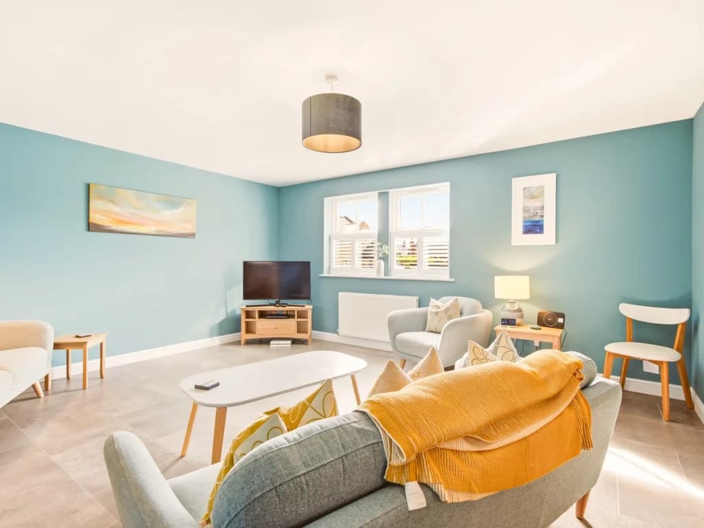 Spacious lounge with Smart TV, comfortable seating and blue feature walls