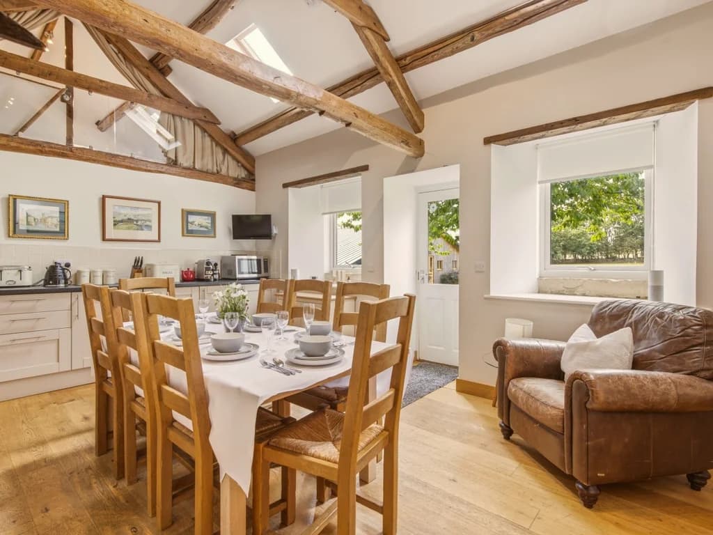 Open-plan kitchen and dining area beneath original timber beams