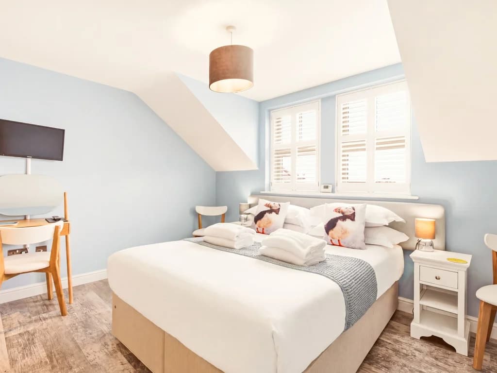 Bright king-size bedroom with Smart TV, dressing table and bedside tables