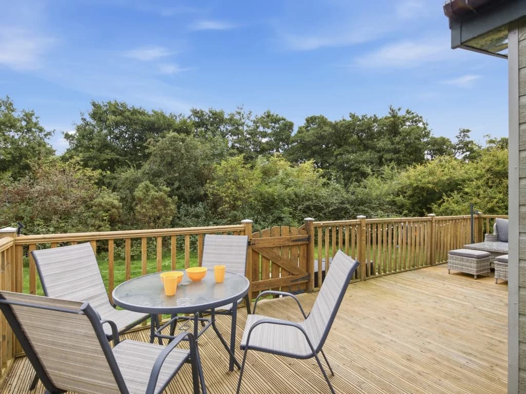 Private deck with outdoor dining furniture overlooking surrounding greenery