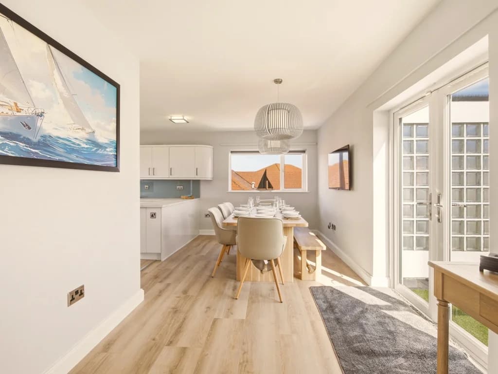 Contemporary dining area flowing seamlessly into the fully equipped kitchen