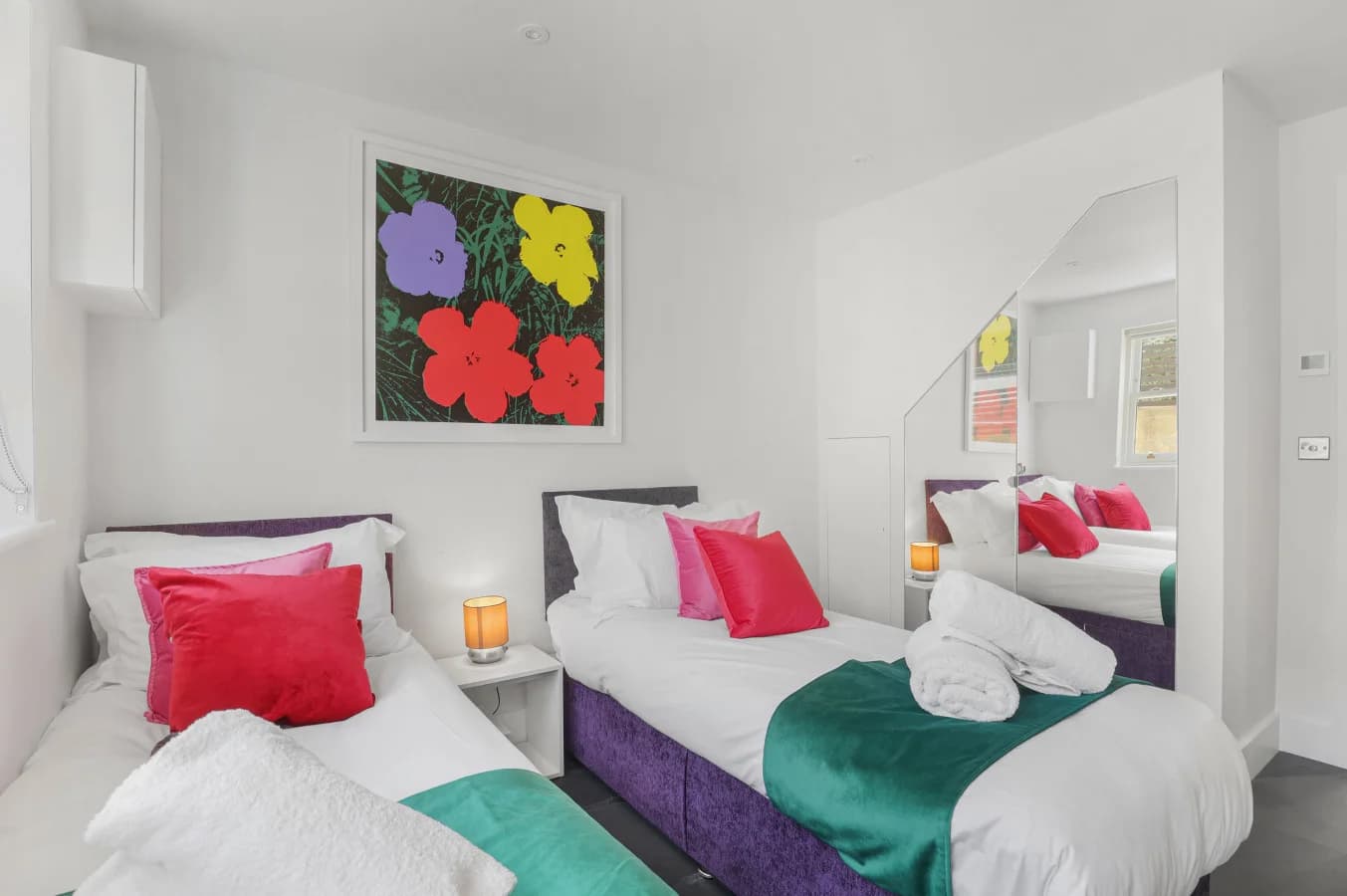 Ground-floor twin bedroom with colourful floral artwork