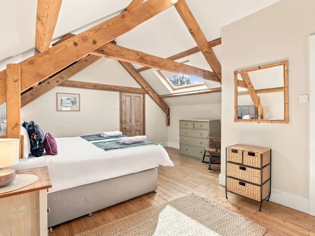 Super king bedroom with wooden floors and original timber beams