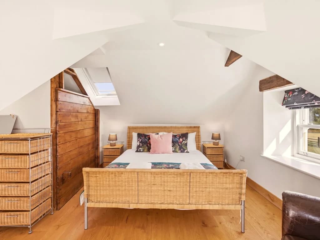 Spacious Hayloft bedroom with queen bed and countryside windows