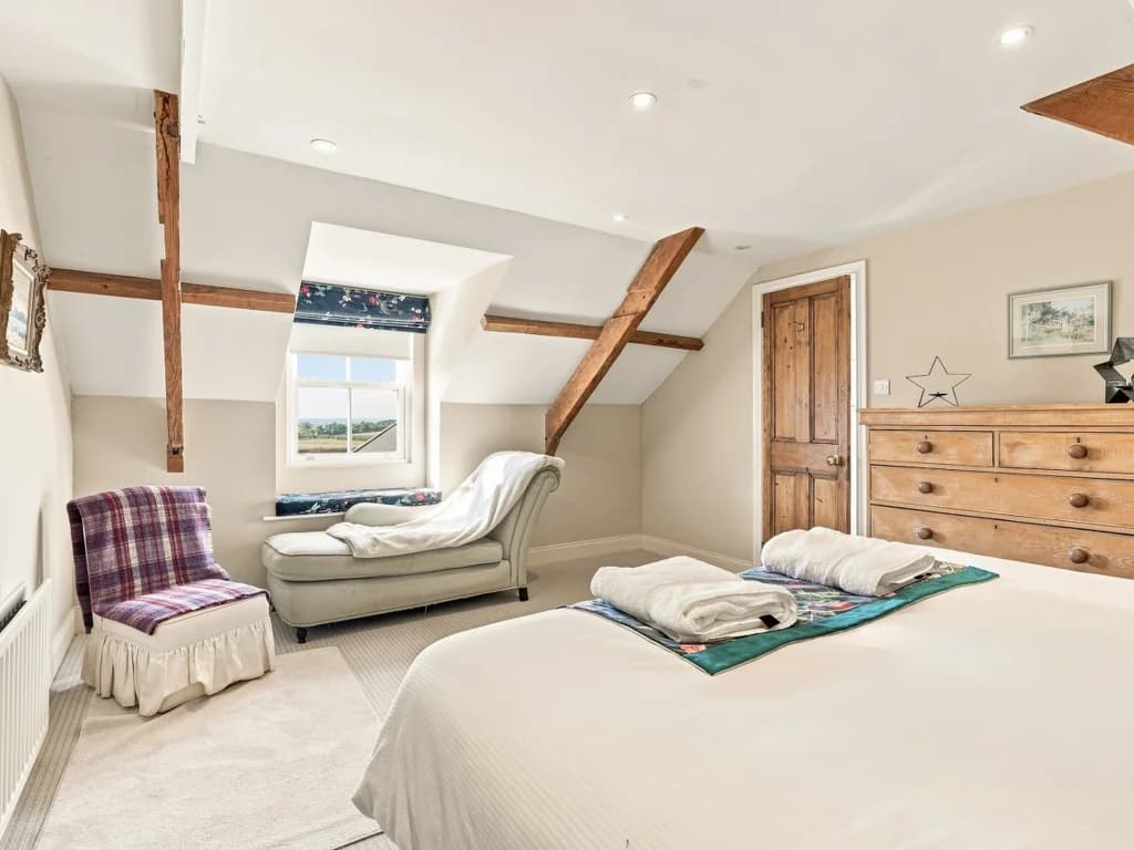King bedroom with countryside window and comfortable seating