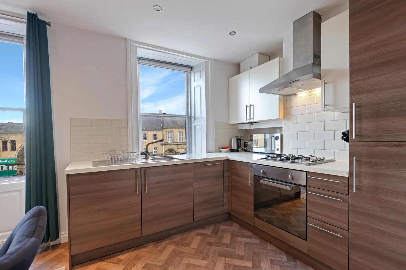 Modern kitchen with walnut-effect cabinetry and herringbone-style flooring