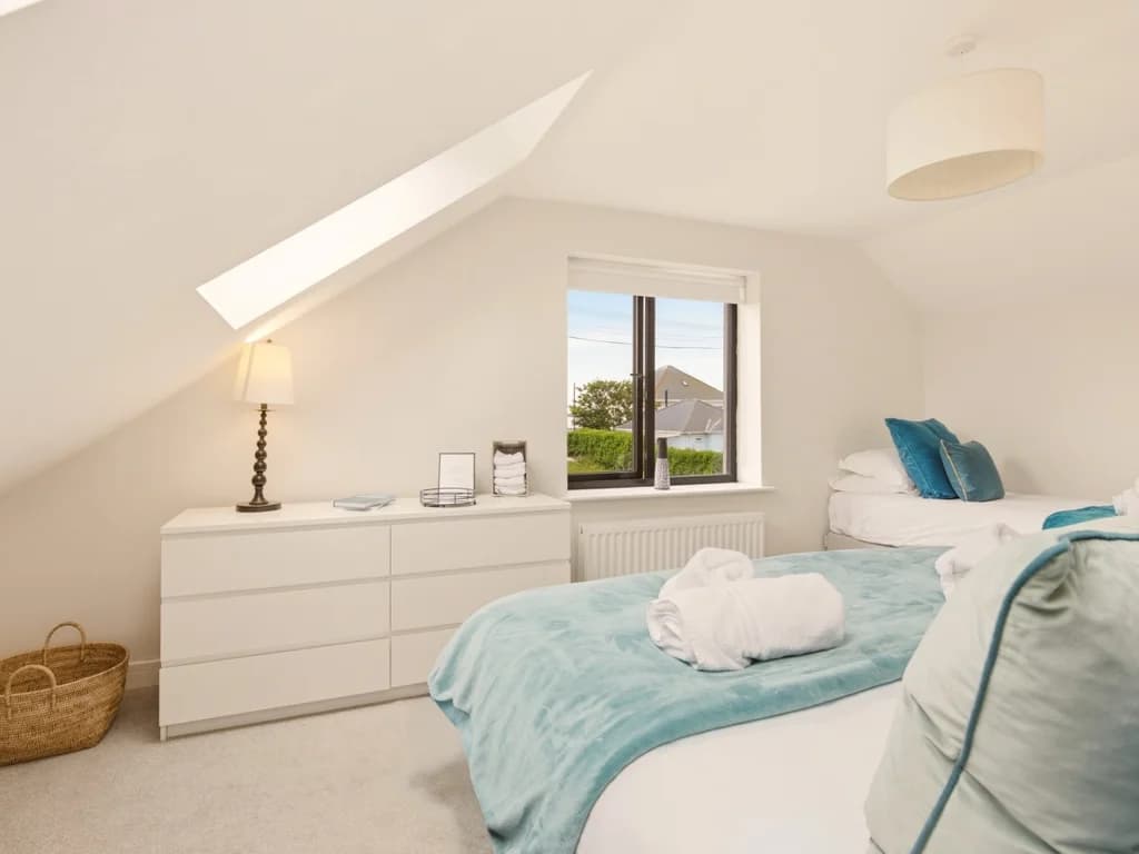 Bright family bedroom with super king, single bed and chest of drawers