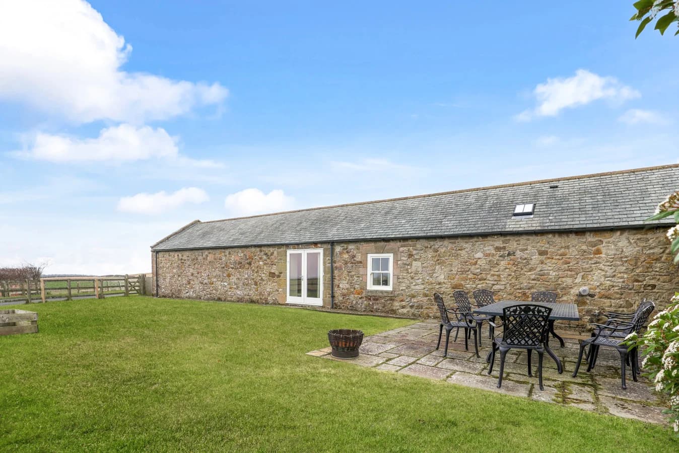 Spacious lawned garden with patio seating and countryside views