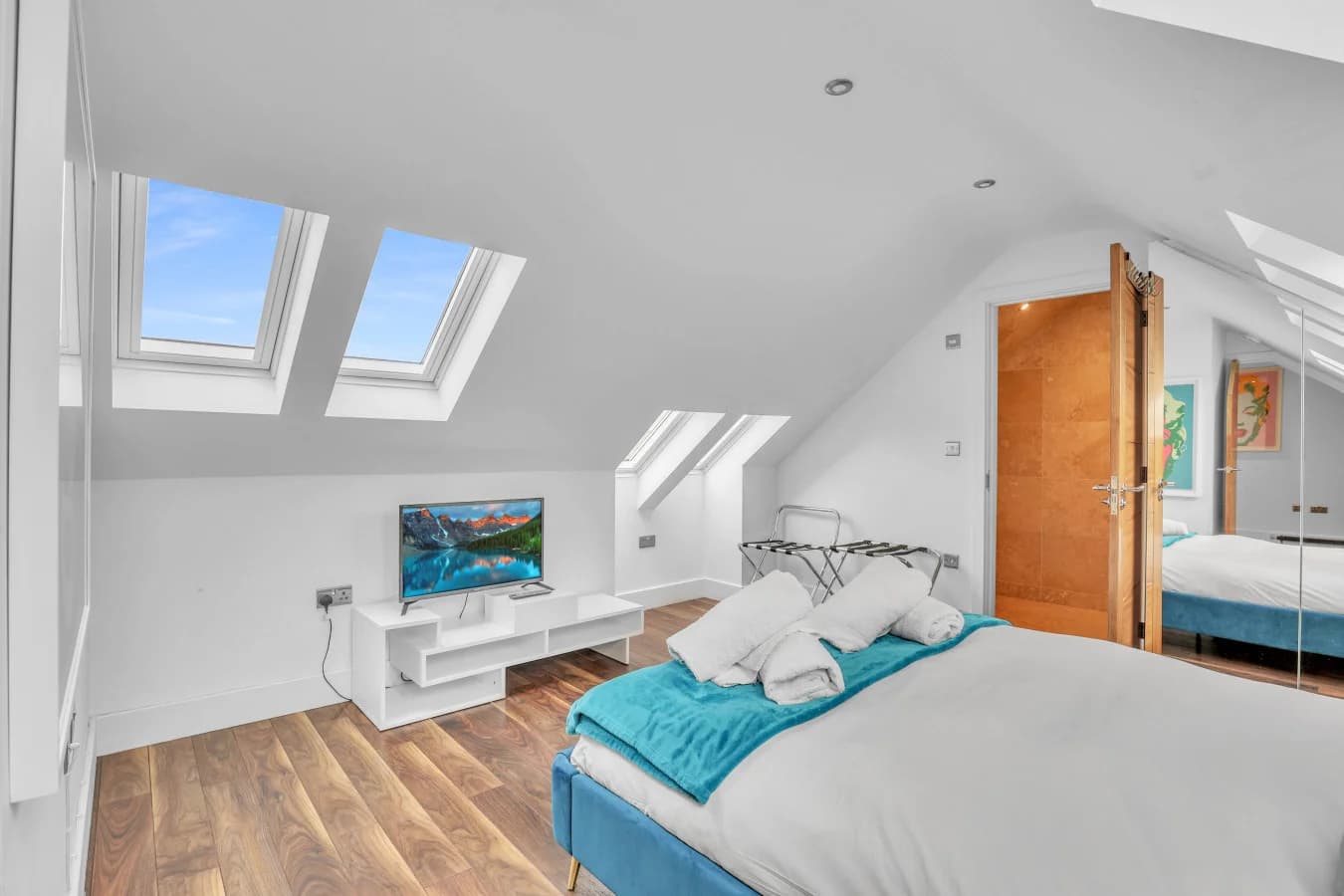 Bright and airy bedroom beneath vaulted ceilings