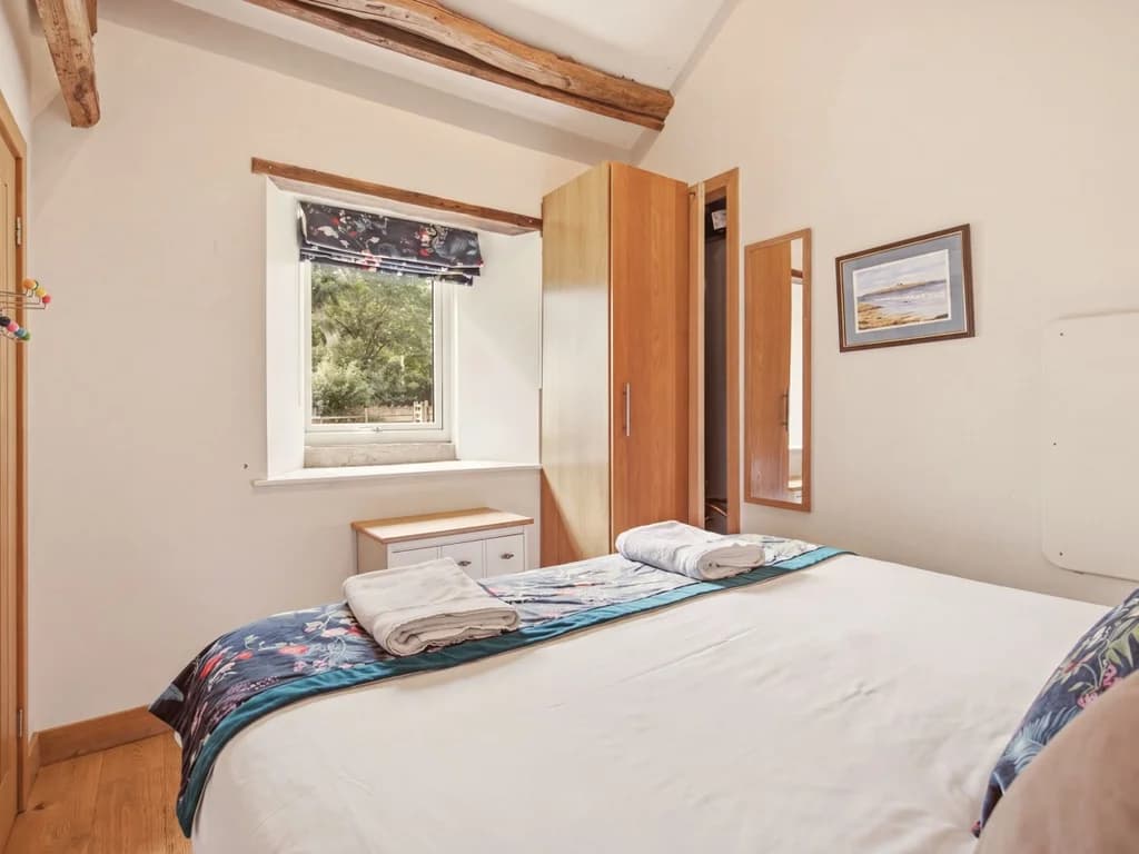 Bedroom with countryside window, wooden floors and timber details