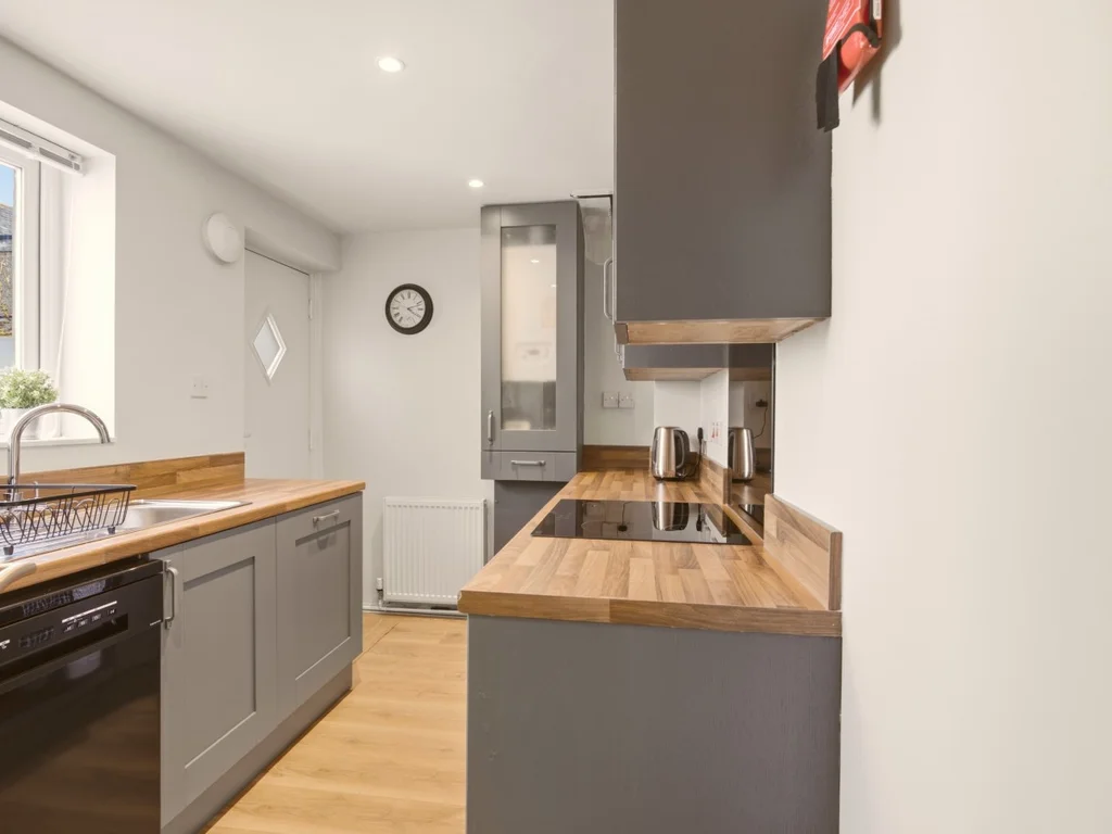Galley kitchen with wooden worktops and grey shaker cabinets