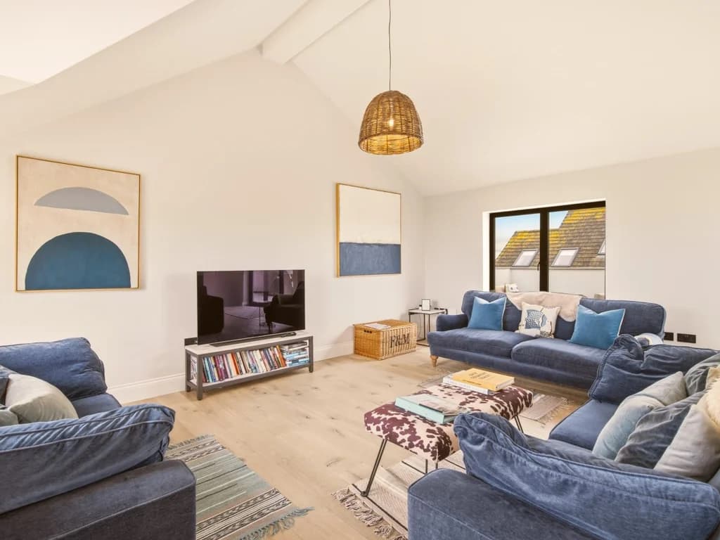 Spacious lounge with plush blue sofas beneath striking vaulted ceilings