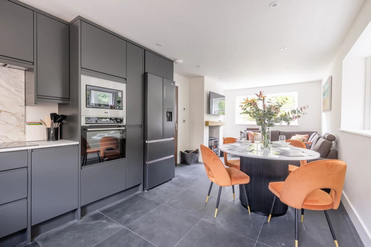 Open-plan kitchen and dining area with charcoal cabinetry