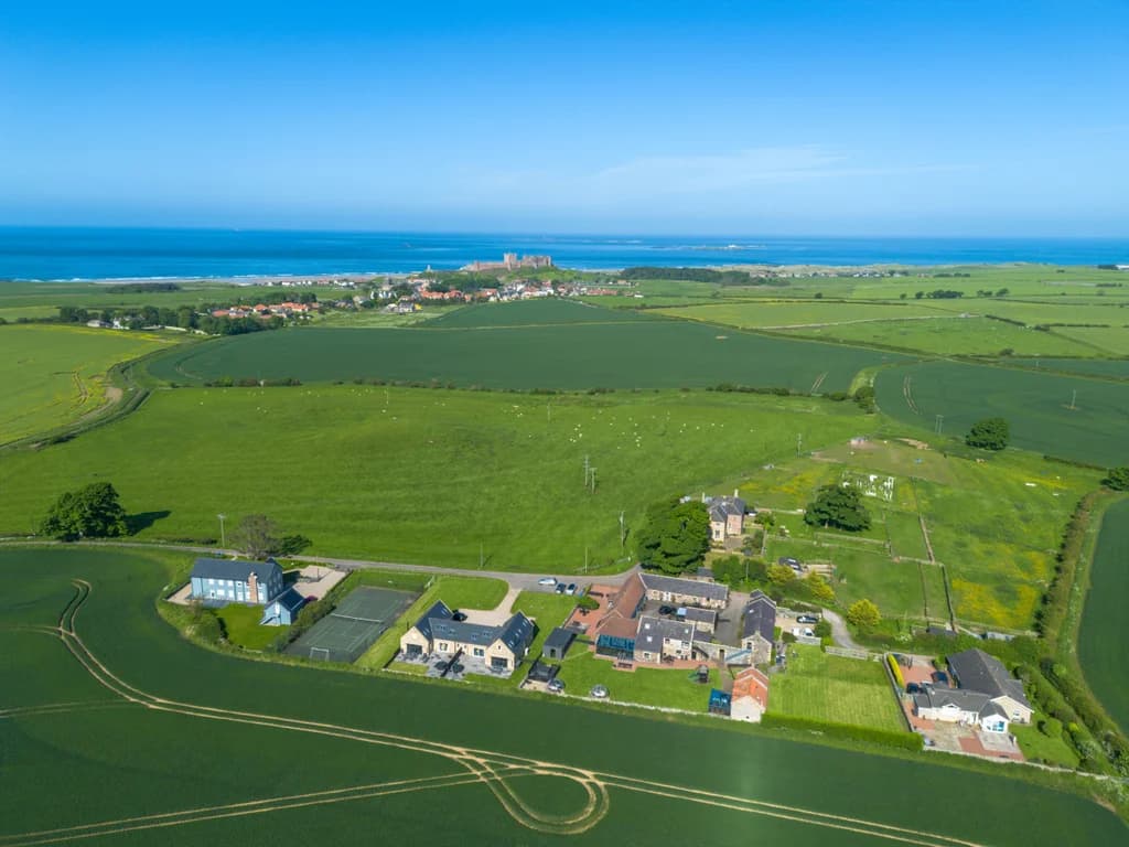 Aerial view of Dukesfield cottages, surrounding fields and coastline.