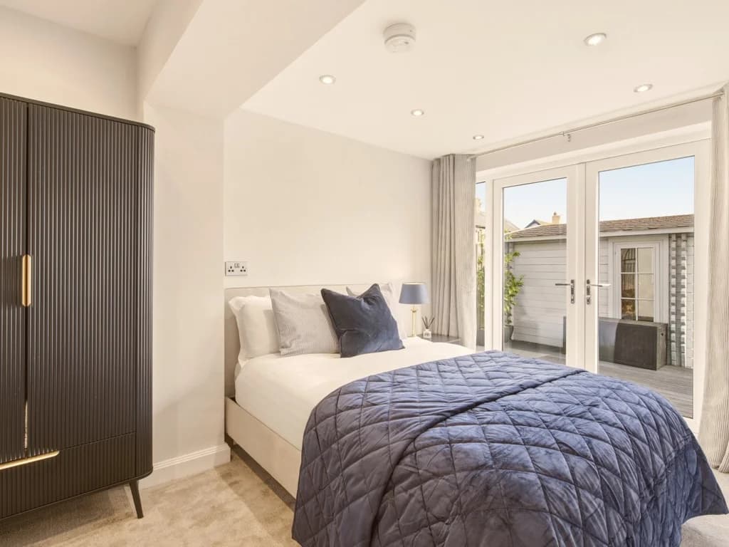 Elegant double bedroom with en-suite and patio doors opening onto the garden
