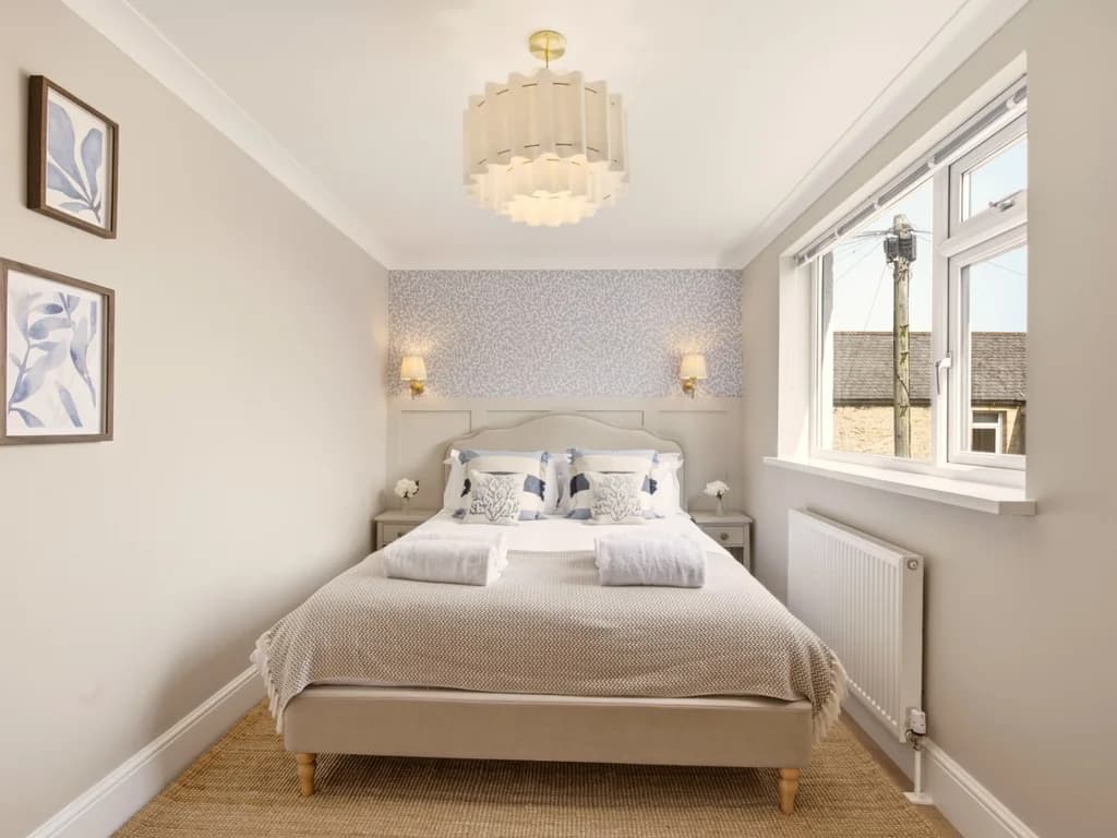 King bedroom with feature wallpaper and upholstered bed