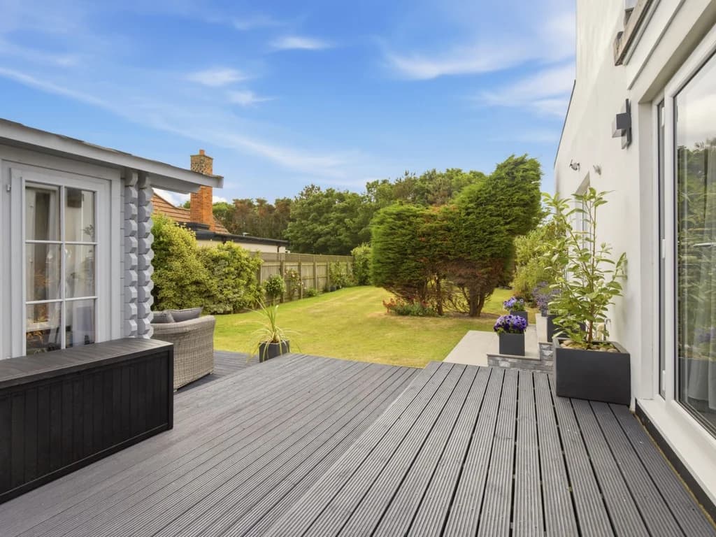 Spacious decked patio with French doors opening onto the private garden
