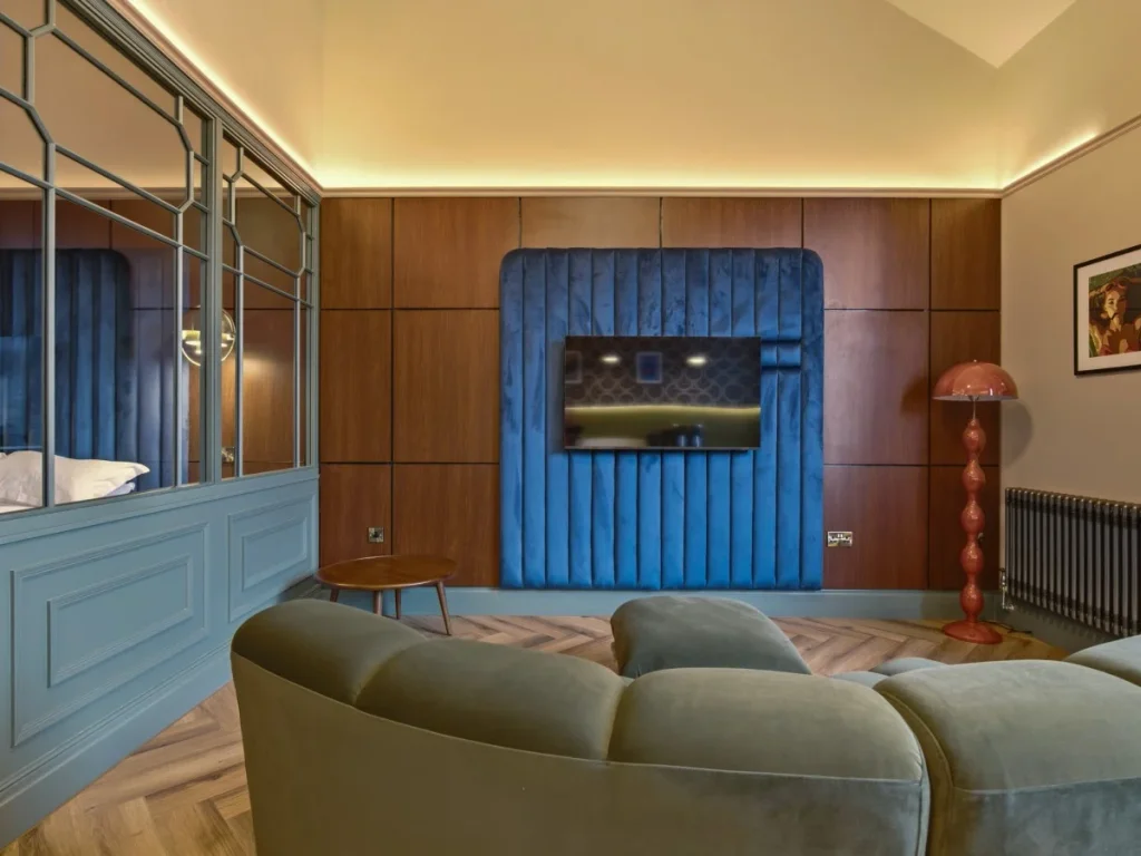 Curved sofa facing the Smart TV with decorative bedroom screen alongside.