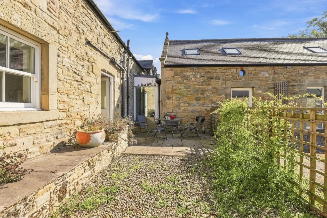 Private courtyard with outdoor seating beside the stone cottage