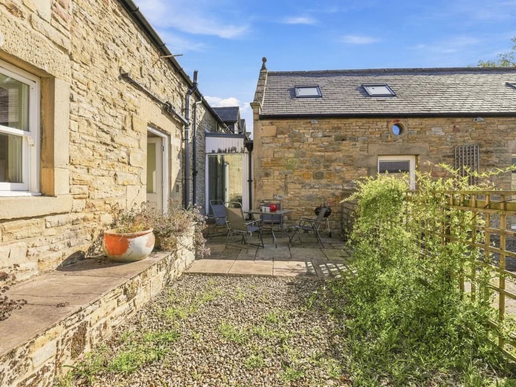 Private courtyard with outdoor seating beside the stone cottage