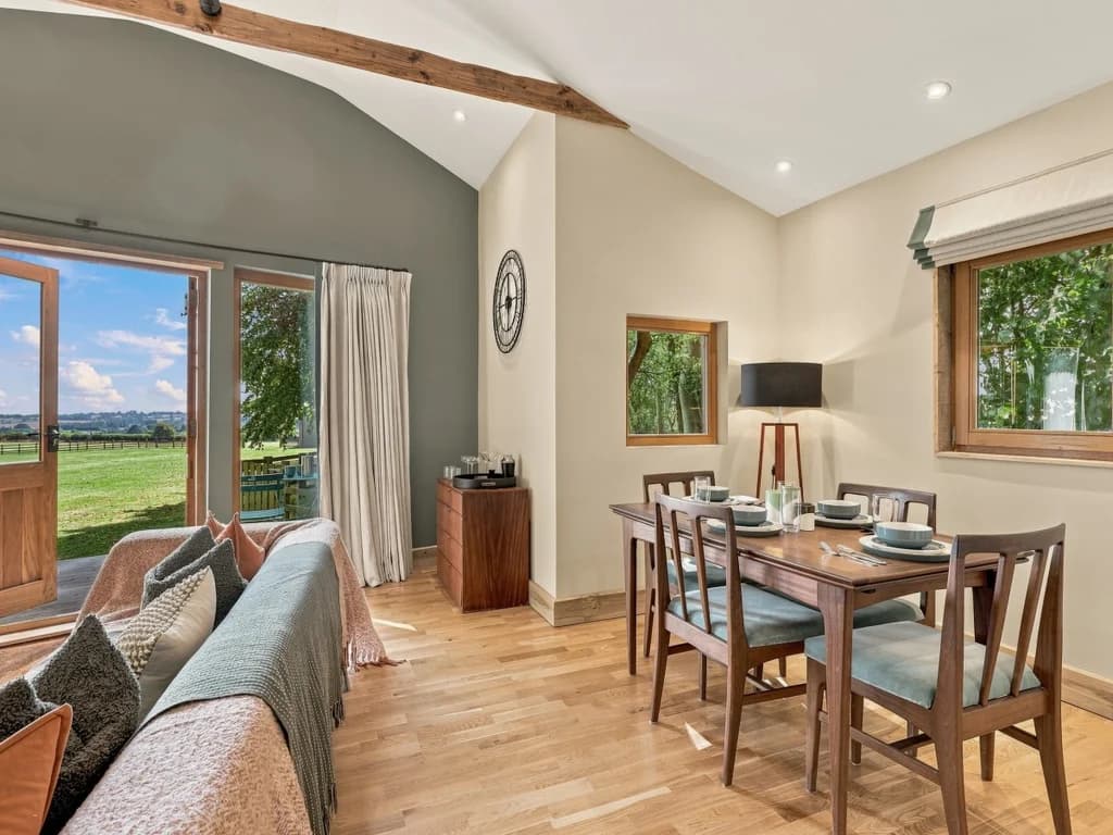 Dining area beside full-height doors with far-reaching rural views