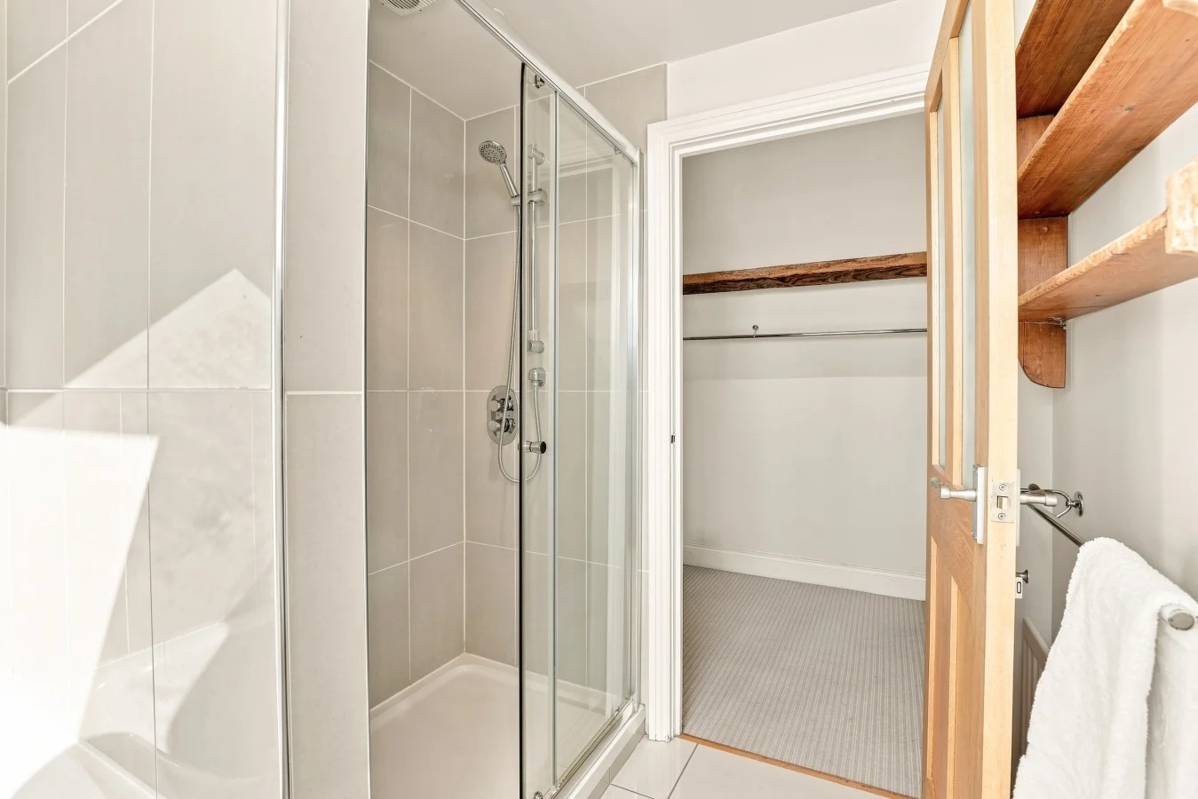 Glass shower enclosure beside a useful storage area