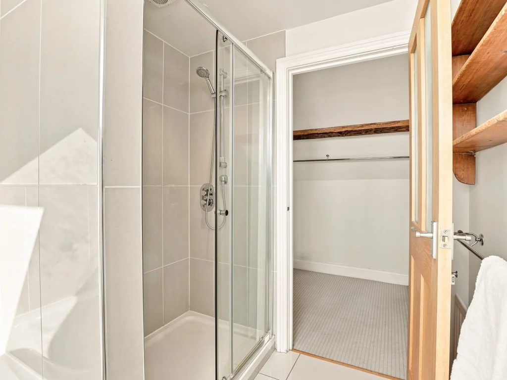 Glass shower enclosure beside a useful storage area