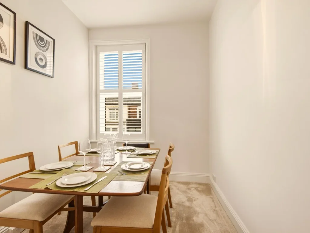 Dining area with table for six, place settings and natural window light