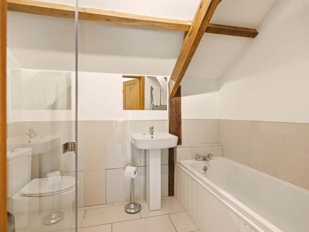 En-suite bathroom with bath, shower screen, WC and wash basin
