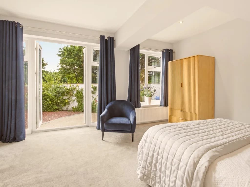 Light-filled king bedroom with garden access and comfortable seating area