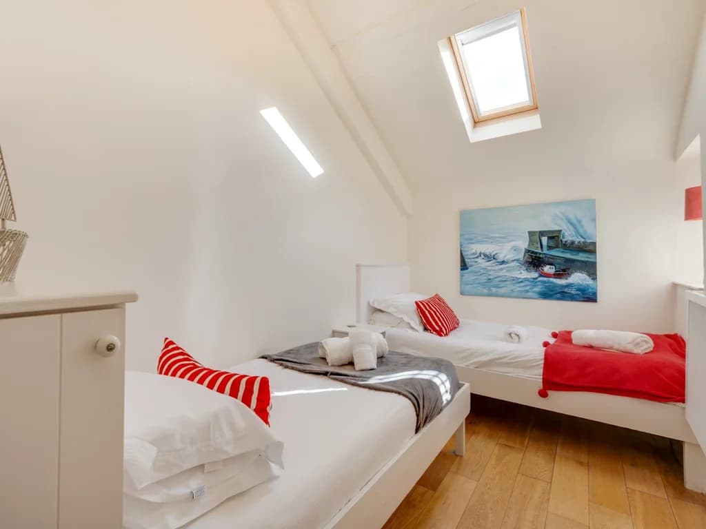 Bright twin bedroom with two single beds and charming coastal touches.
