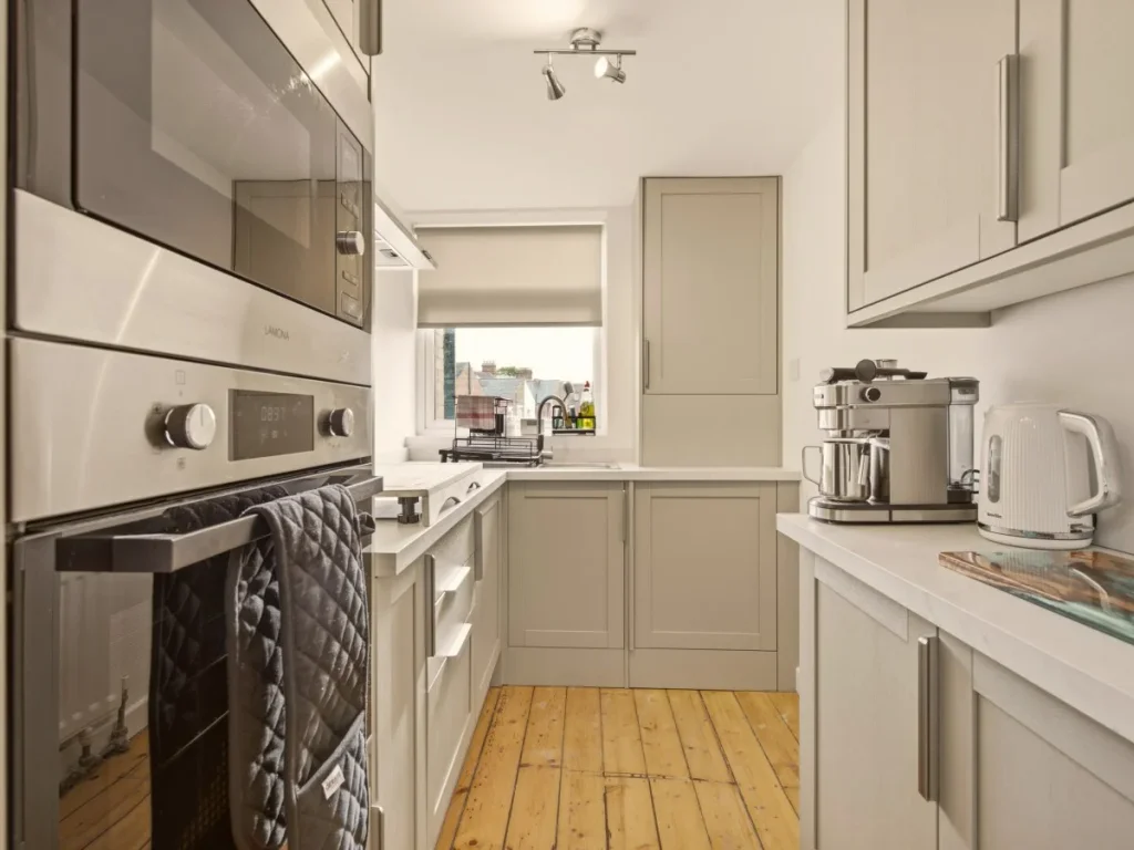 Well-equipped kitchen with oven, microwave, coffee machine and storage