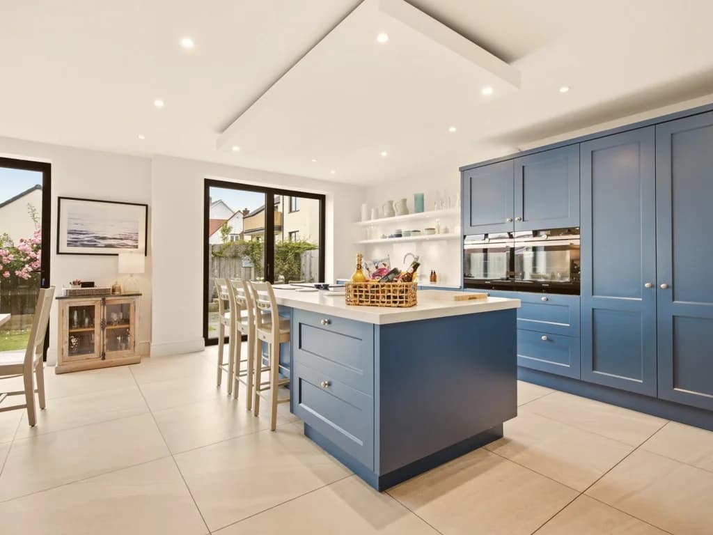 Contemporary kitchen with blue cabinetry, island seating and garden access