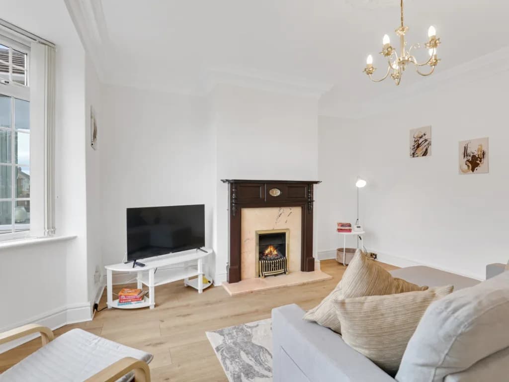 Living room with TV, feature fireplace and plenty of natural light