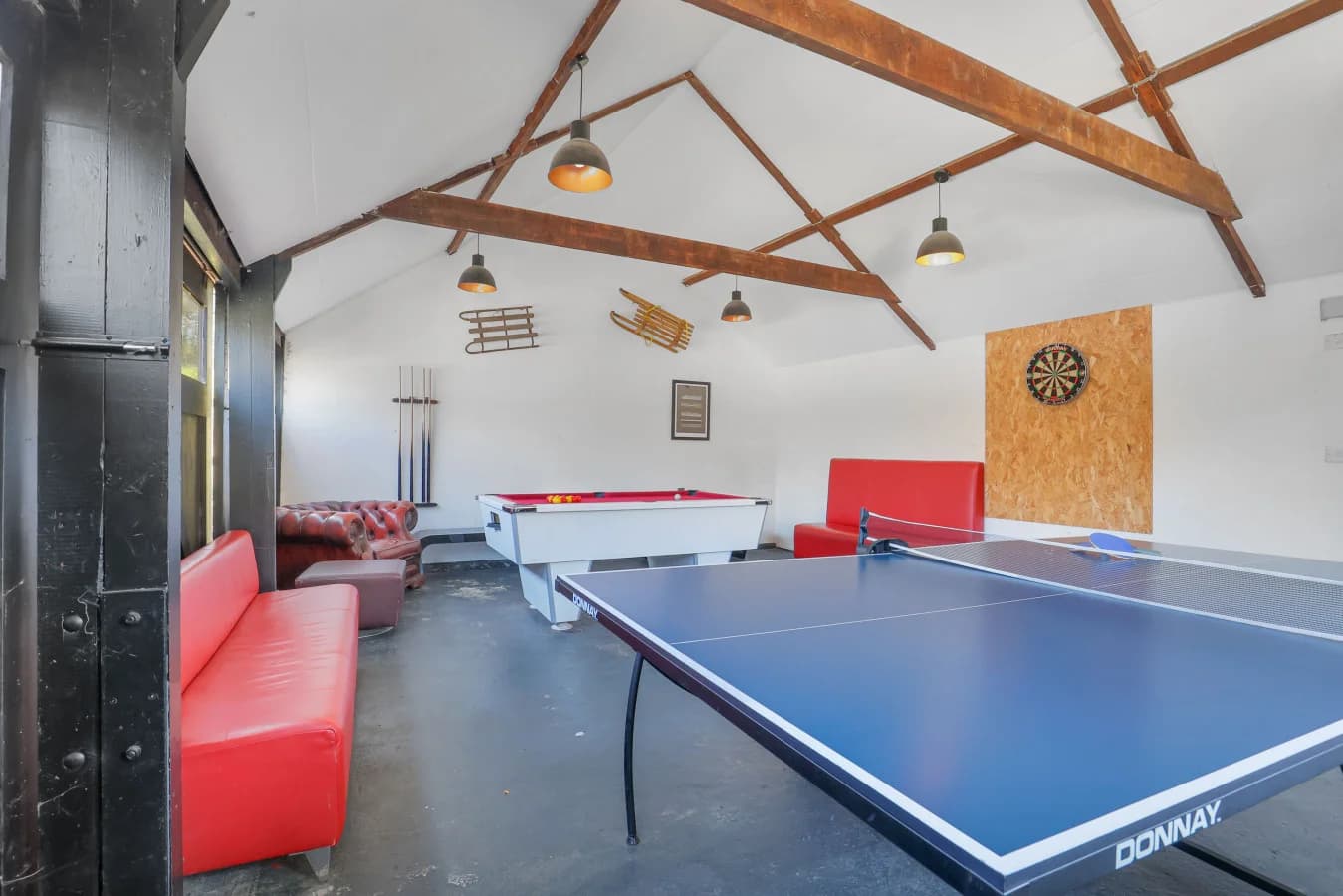 Shared games room with table tennis, pool table and exposed roof trusses