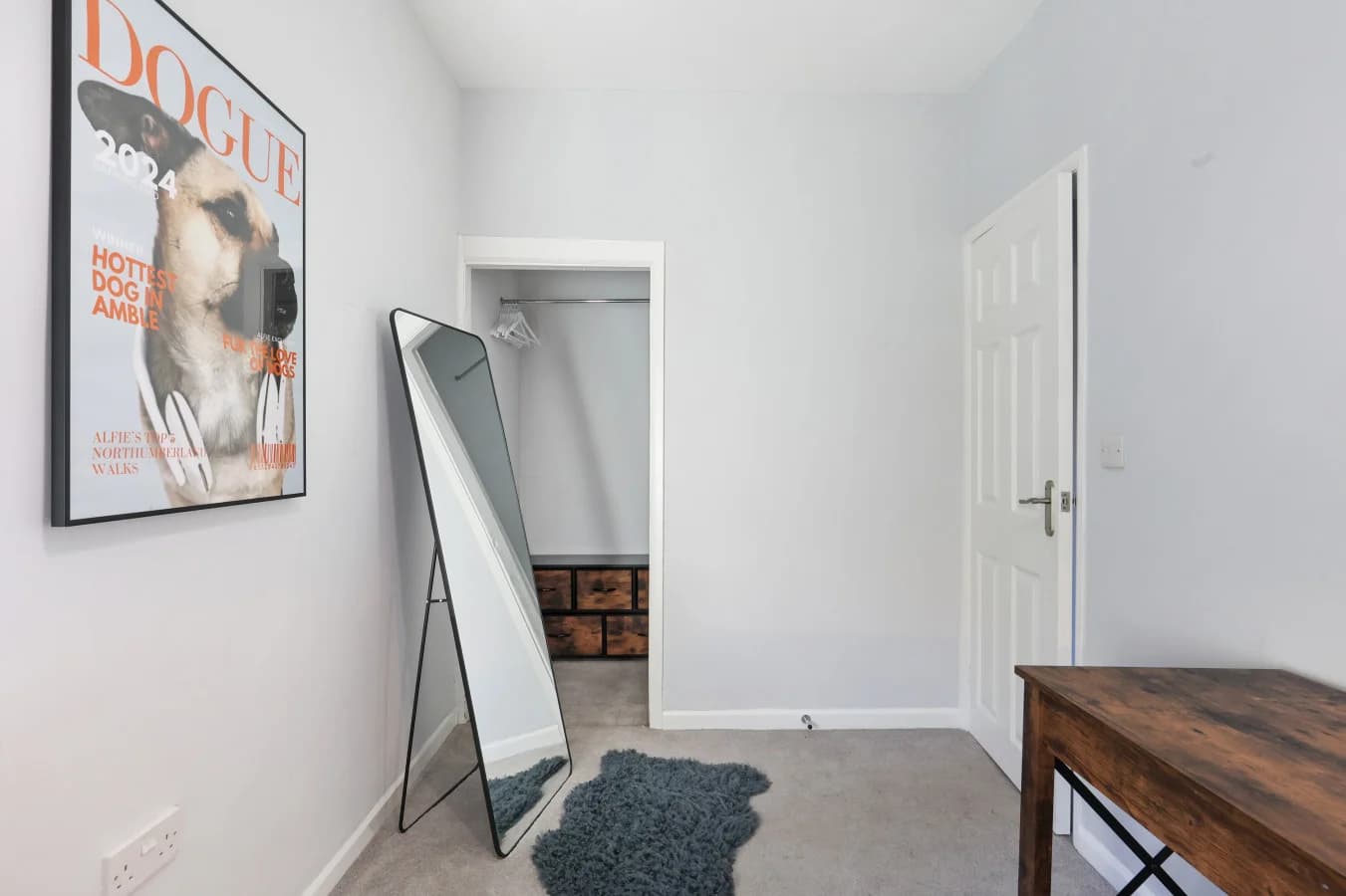 Spacious guest room with open hanging space, full-length mirror and desk