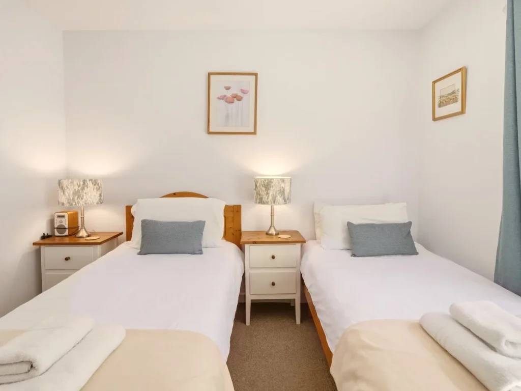Twin bedroom with two single beds, bedside storage and reading lamps