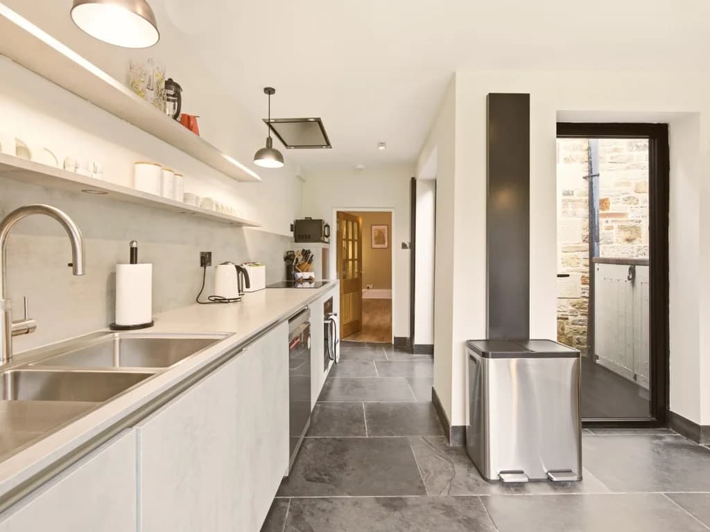 Modern fitted kitchen with garden access and ample preparation space.