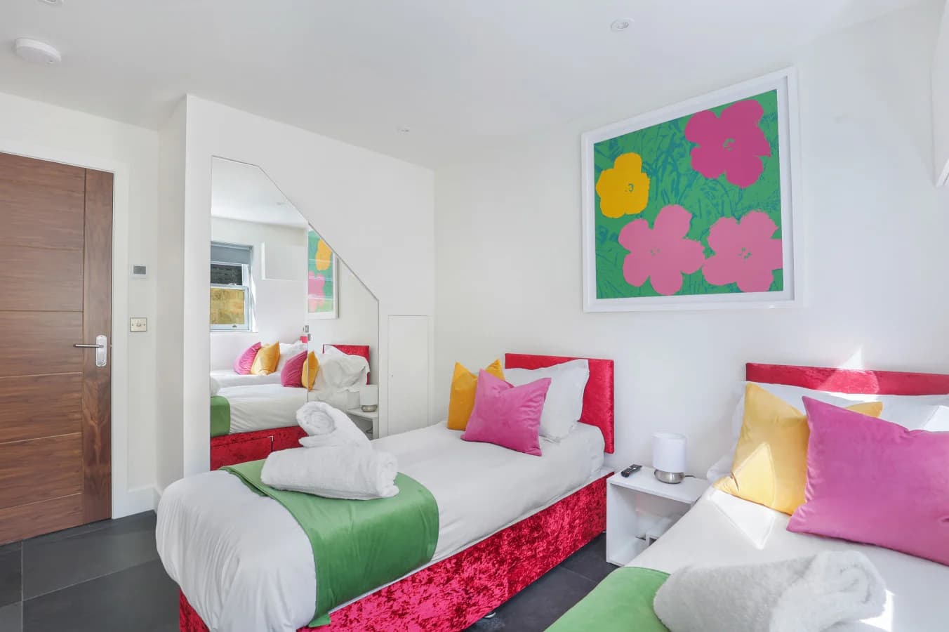 Twin bedroom with floral artwork and bedside table