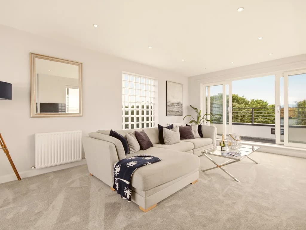 Bright contemporary lounge with balcony access and relaxing coastal ambience