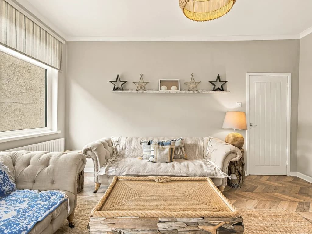 Living room with feature fireplace, coastal décor and large seating area.