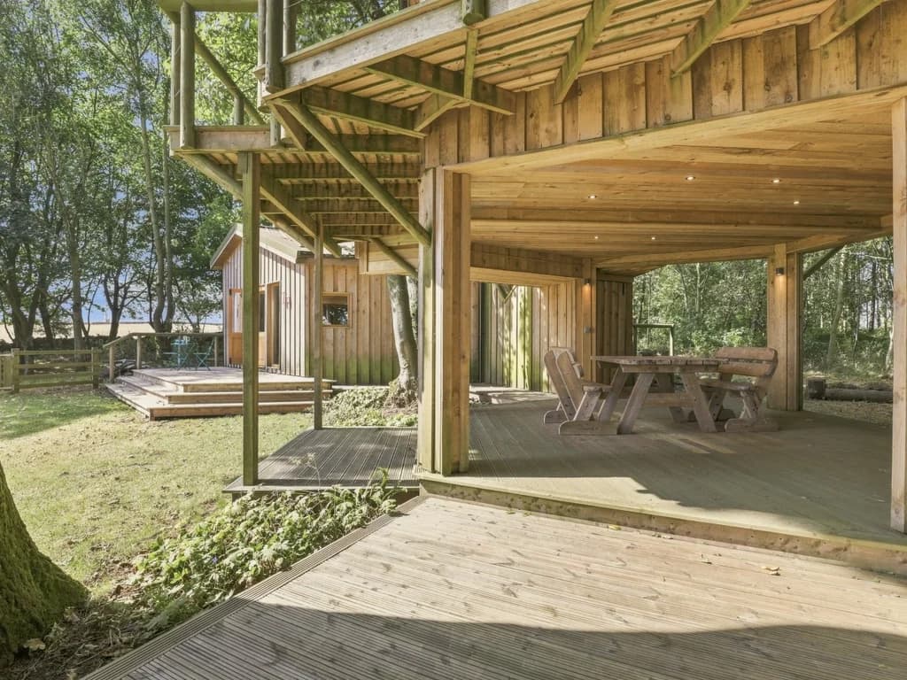 Covered outdoor seating beneath the raised timber balcony